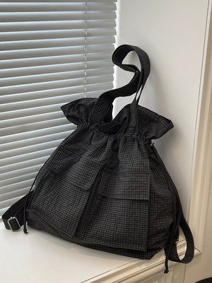 Chic plaid drawstring backpack in grey with multiple pockets and adjustable straps.