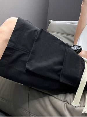 Black relaxed fit cargo shorts with drawstring and flap pockets.