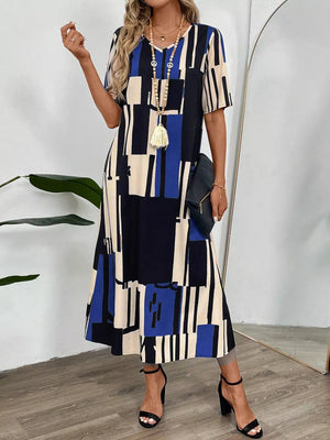 Geometric v-neck midi dress in dark blue, cream, and black abstract print with short sleeves.