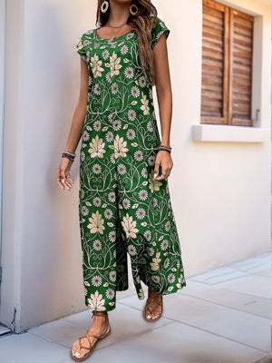 Dark green botanical print culotte jumpsuit with short sleeves and a scoop neck.
