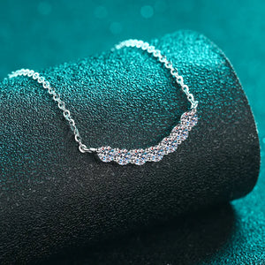 Silver moissanite necklace with a curved row of sparkling stones.