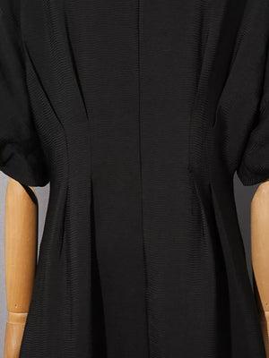 Black midi dress with puff sleeves and textured fabric.