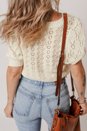 Cream lace-effect knit top with puff sleeves and diamond pattern detail.