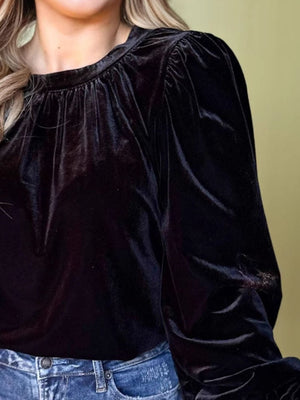 Black velvet ruched blouse with long puff sleeves and a gathered neckline.