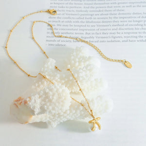 Gold bow-adorned pearl drop necklace with beaded chain detail