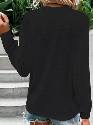 Black lace-effect henley blouse with button detail and long sleeves.