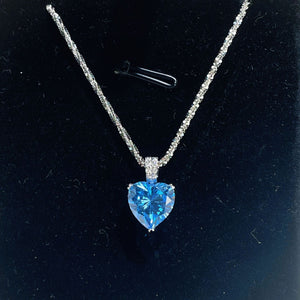 Dazzling heart pendant necklace in silver with a blue stone and delicate chain.