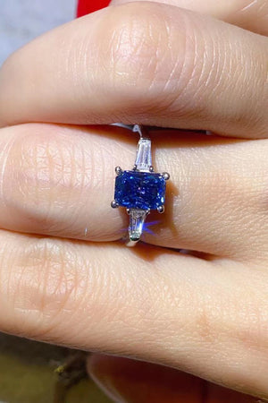 Blue sapphire prism moissanite ring with baguette side stones in sterling silver.