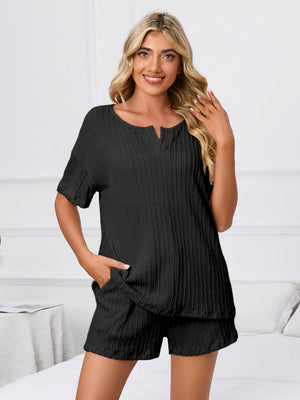 Black textured ribbed knit pajama set with short sleeves and notched neckline, featuring pockets.