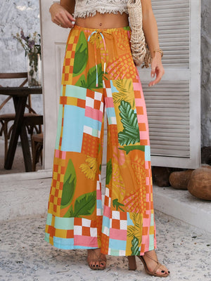 Geometric print wide-leg trousers with drawstring waist in multicolor patchwork pattern.