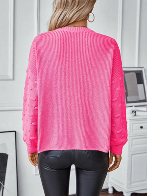 Hot pink knit sweater with textured sleeves and ribbed detail, crew neck, long sleeves.
