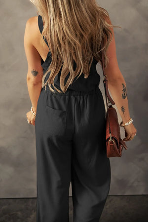 Black waffle knit wide leg jumpsuit with pockets, styled with a brown crossbody bag.