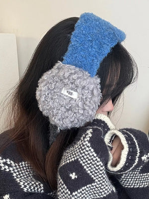 Plush sherpa earmuffs with textured blue headband and gray earcups.