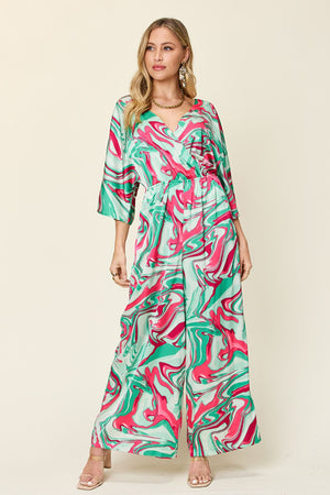 Green swirl print kimono sleeve jumpsuit with wide legs and a wrap neckline.