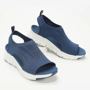 Blue breathable open-toe wedge sandals with a chunky white sole and knit upper.
