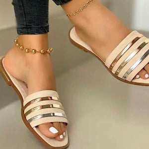 Beige open-toe flat sandals with metallic stripe detail.
