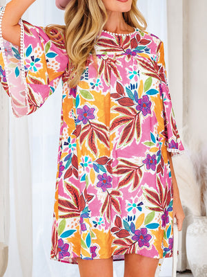 Print bell sleeve mini dress with floral pattern and white pom-pom trim.