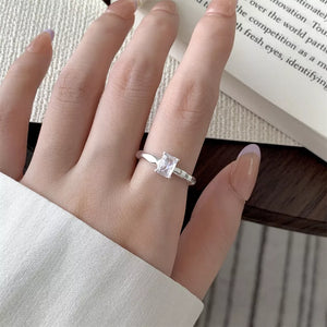 Sleek silver ring with a rectangular clear zircon stone on a textured band.
