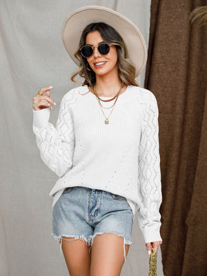 White diamond-cut raglan knit sweater with crew neck and long sleeves.
