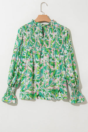 Green abstract floral print blouse with smocked yoke and voluminous sleeves.