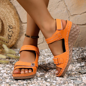 Orange wedge sandals with adjustable straps and textured sole detail.