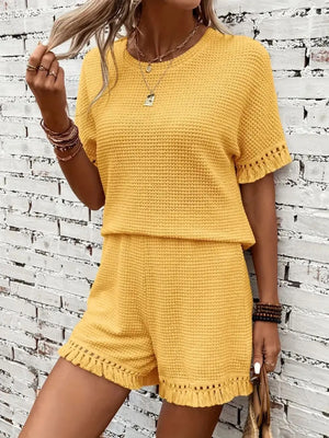 Textured knit set in gold with fringe trim on short sleeves and hem.