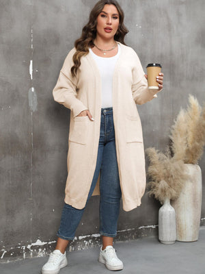 Cream oversized knit duster cardigan with patch pockets and ribbed trim.
