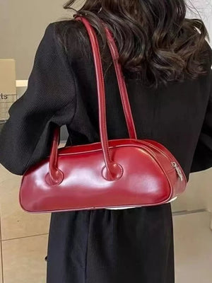 Chic red barrel shoulder bag with double handles and a silver zipper detail.