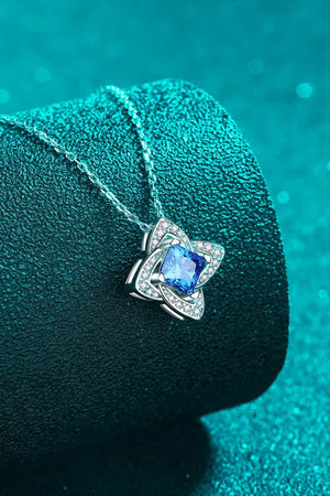 Sky blue moissanite and diamond pendant necklace with floral design.