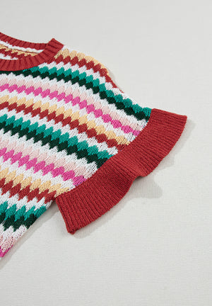 Textured knit sweater with multicolor chevron stripes and contrast red trim on sleeves and neckline.