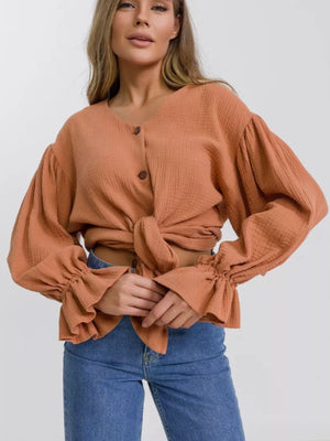 Ochre textured puff sleeve blouse with ruffled cuffs and tie front.