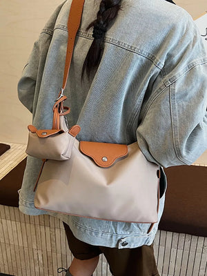 Elevated canvas hobo bag in ivory with coin purse and brown trim.