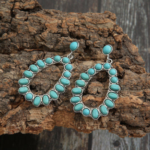 Teal teardrop statement earrings with artificial turquoise stones and silver alloy details.