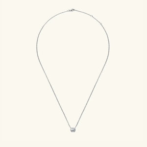 Silver necklace with emerald cut moissanite solitaire pendant and gold bezel.