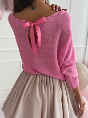 Fuchsia pink knit sweater with batwing sleeves and a bow-tie back cutout.