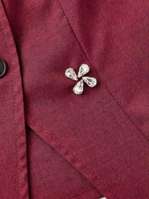 Burgundy vest with crystal flower applique and button front detail.