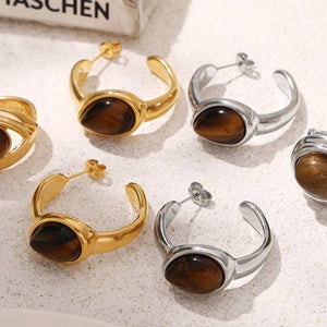 Gold and silver sculptural hoop earrings with tiger's eye stone detail