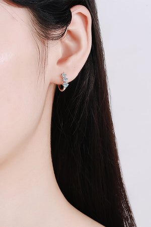 Silver huggie earrings with a triple stone cluster detail.