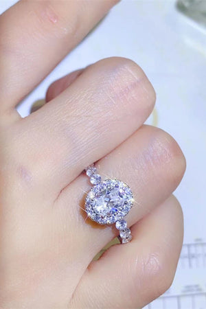 White oval moissanite halo ring with sparkling accent stones on band