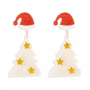 White acrylic Christmas tree dangle earrings with Santa hats and gold stars.