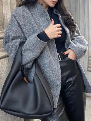 Gray boucle cocoon jacket with snap closure and stand-up collar, styled with black top and leather pants.