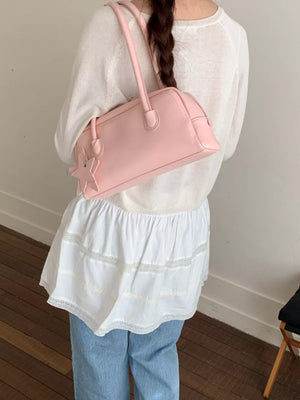 Pink shoulder bag with star charm detail and double handles.