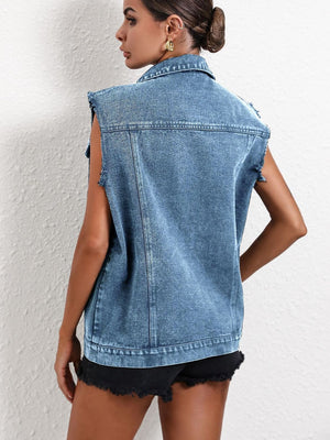 Medium wash denim vest with raw edge sleeves and collar, buttoned front, and collared neckline.
