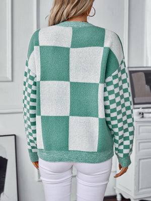 Checkerboard knit sweater in turquoise and white with a crew neck and long sleeves.