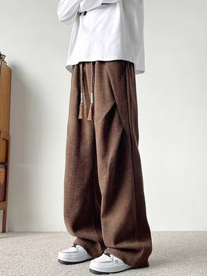 Brown herringbone drawstring sweatpants with a relaxed fit and tasseled drawstrings.