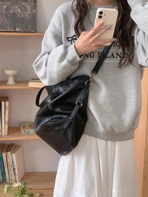 Black pu leather crossbody bag with adjustable strap and silver hardware.