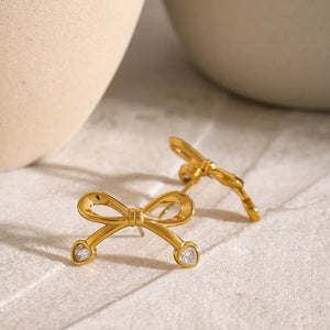 Gold cubic zirconia bow stud earrings with heart-shaped stones