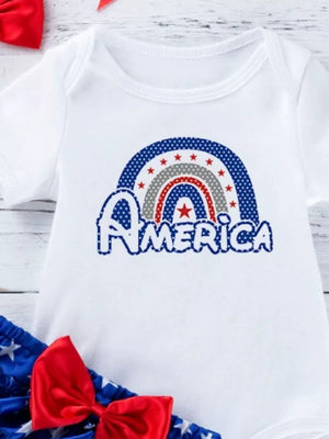 White baby onesie with patriotic rainbow and "America" graphic, part of a set with bloomer and bow.