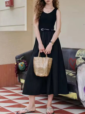 Black midi dress with fitted sleeveless top and flowing skirt, cinched with a belt.