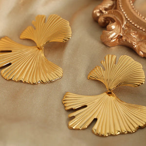 Gold Ginkgo leaf statement earrings with ribbed texture and elegant design.